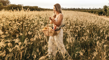 Mother walking through a wheat field holding a basket