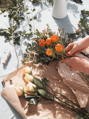 hands bunches orange flowers and eucalpytus