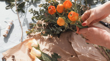 hands bunches orange flowers and eucalpytus