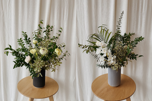 two corporate flower arrangements on stools in vases