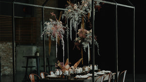 coporate event with hanging florals and black background