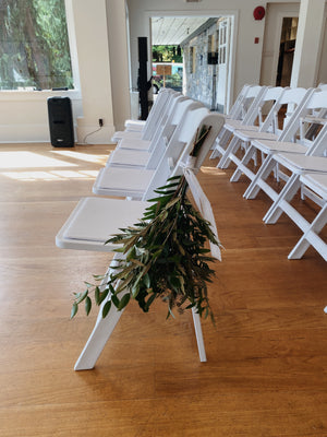 Mixed Greenery pew marker on white chair