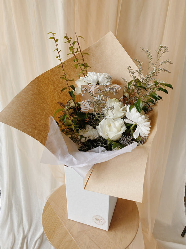 Green and White bouquet in white delivery box wrapped in kraft paper