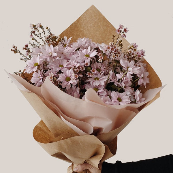 Large spray mum and wax flower filler bouquet wrapped in kraft paper