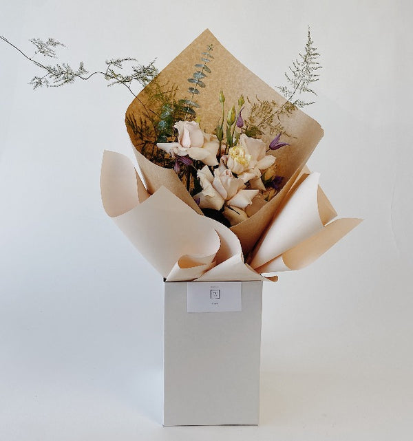 Classic Handtied bouquet in medium size displayed in a delivery box with kraft paper, seasonal flowers and greenery