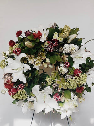 funeral flower wreath with white lilies and red flowers with stand