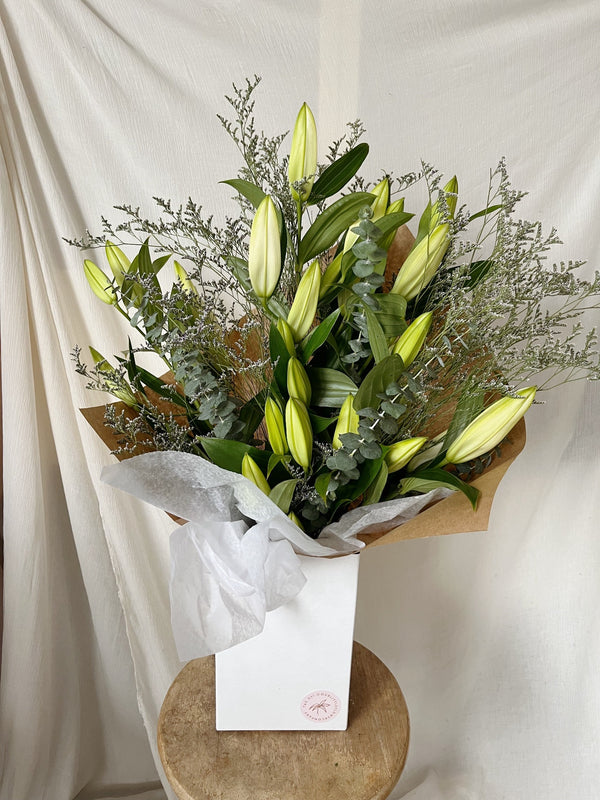 Large close white lily bouquet wrapped for delivery
